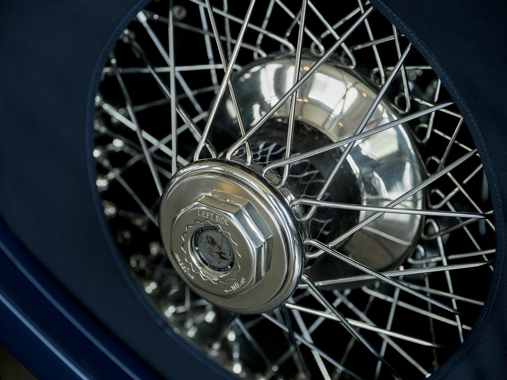 Close view of a chrome wire wheel on a classic motor car