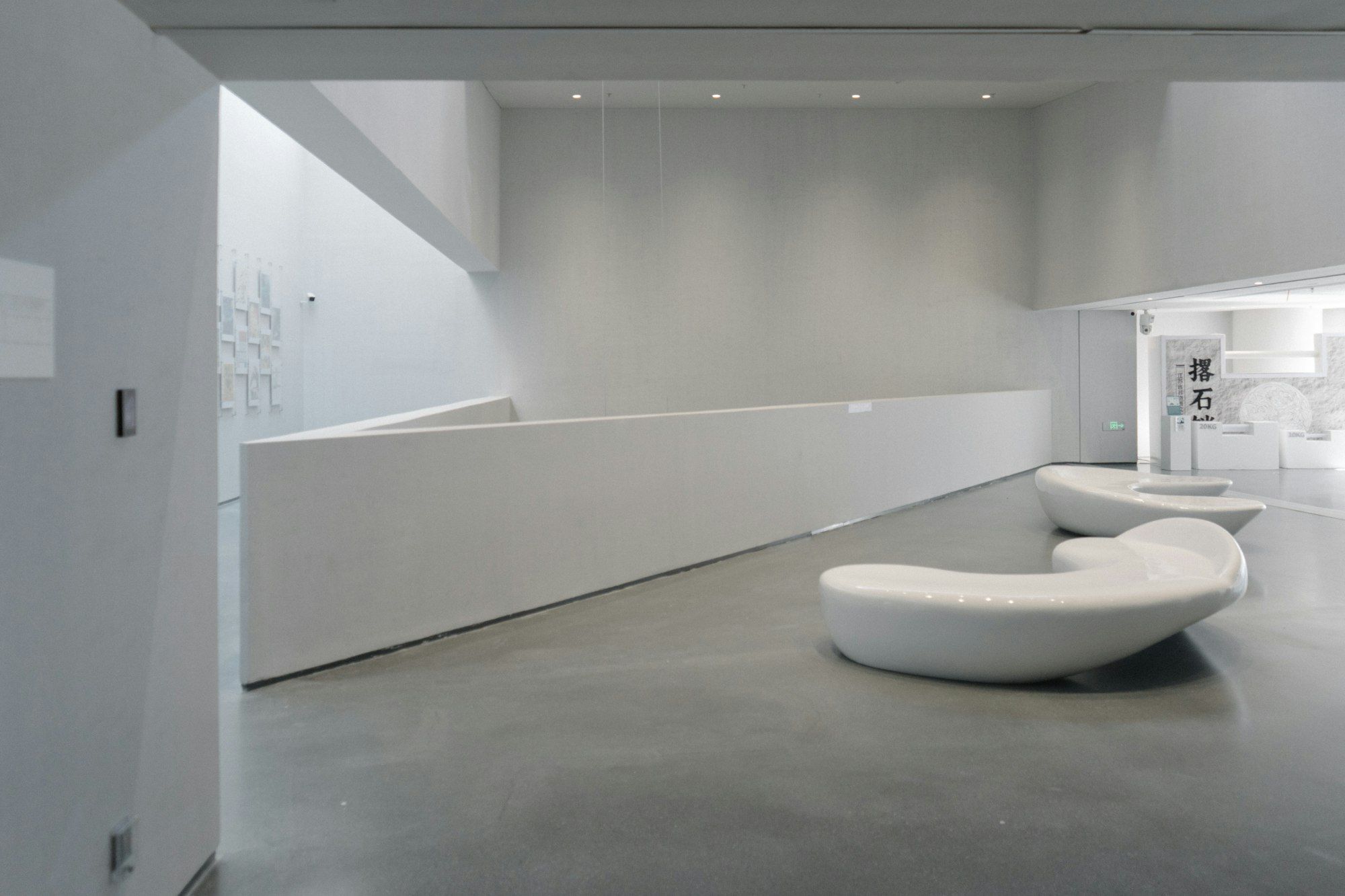Light-filled interior with pale curved seating and a smooth floor