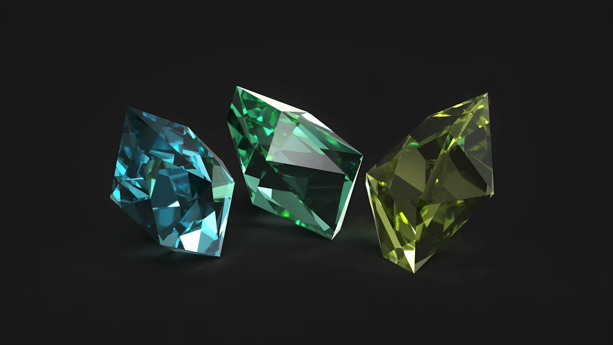 Three faceted coloured stones on a dark surface
