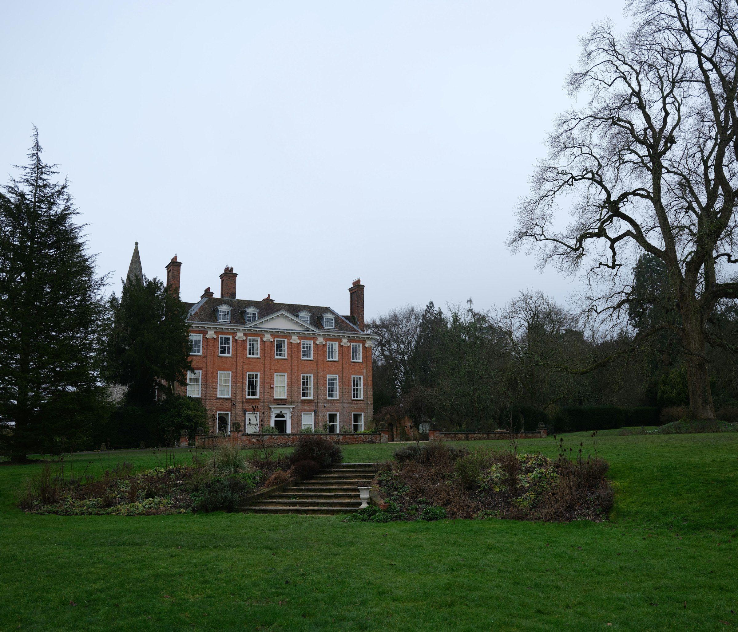 Brick country house set back behind a wide lawn