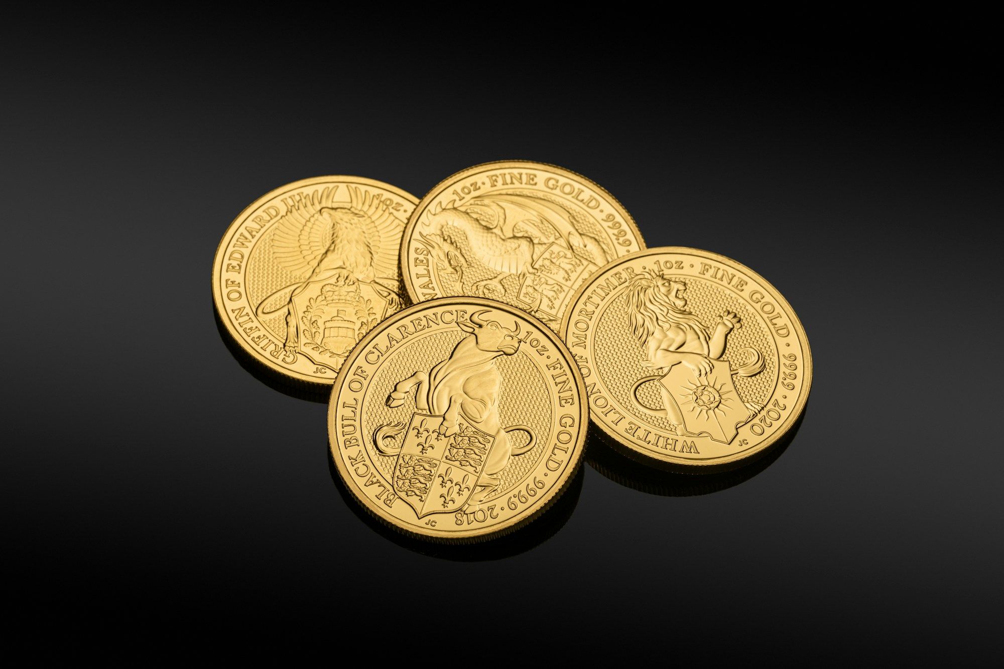 Gold coins resting on a dark surface in low, warm light