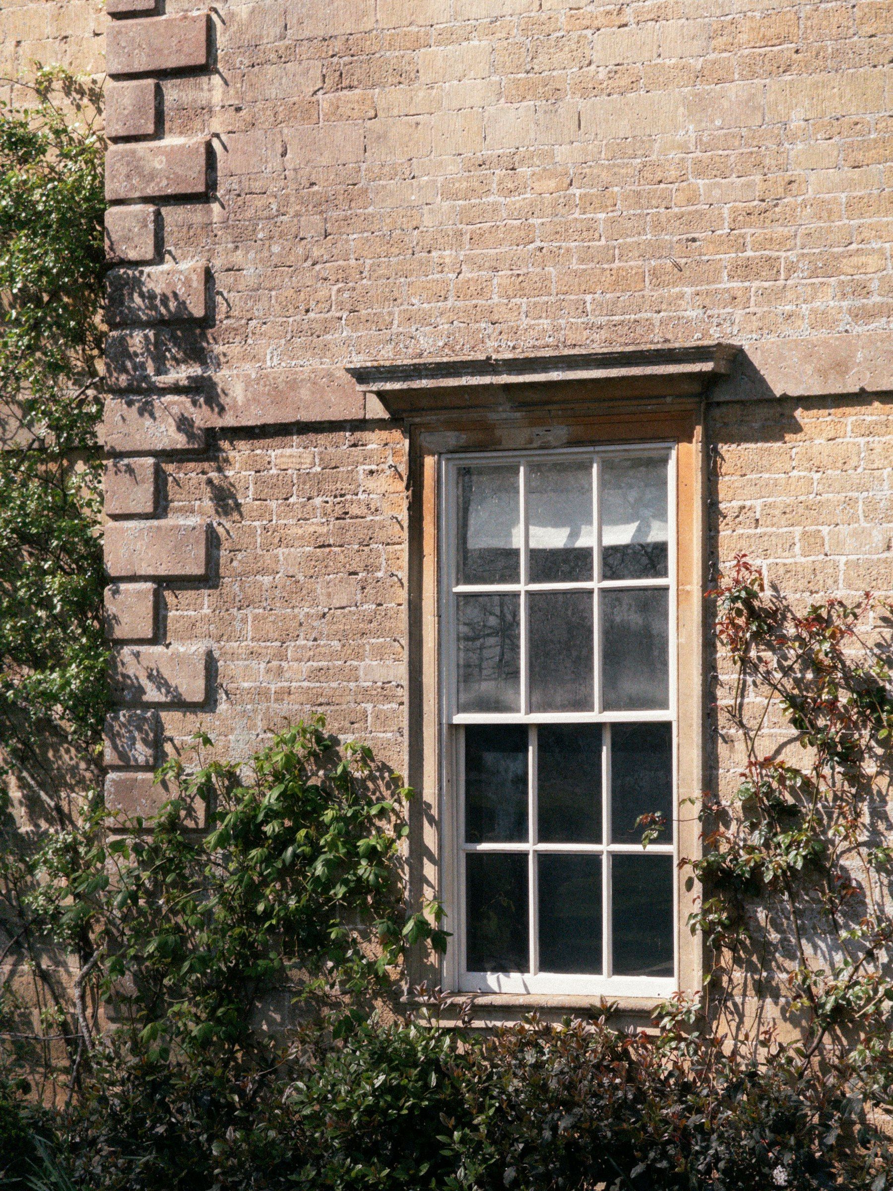 White sash window set into an old brick wall